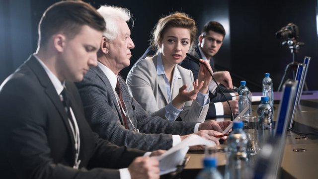 chica llevando a cabo intepretación consecutiva durante una rueda de prensa