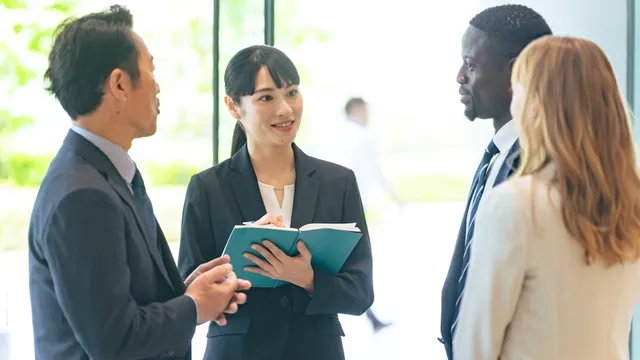 empresarios de distintas nacionalidades conversan en un lobby a través de un intérprete
