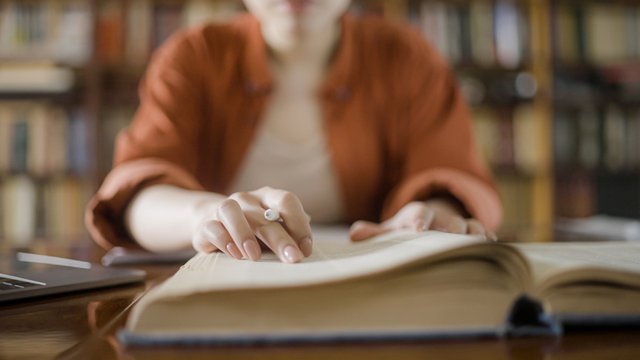 mujer haciendo una investigación en una biblioteca