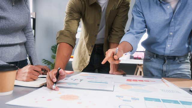 tres personas se encuentran reunidas hablando sobre investigación comercial y negocios