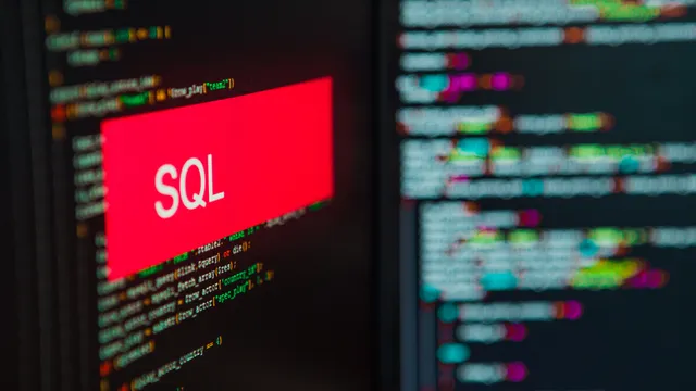 pantalla de ordenador con un letrero rojo que tiene escrita la palabra SQL en blanco