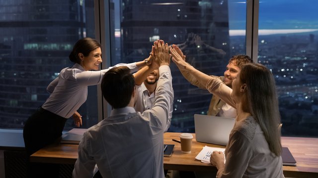 equipo de trabajo unen sus manos celebrando un logro común