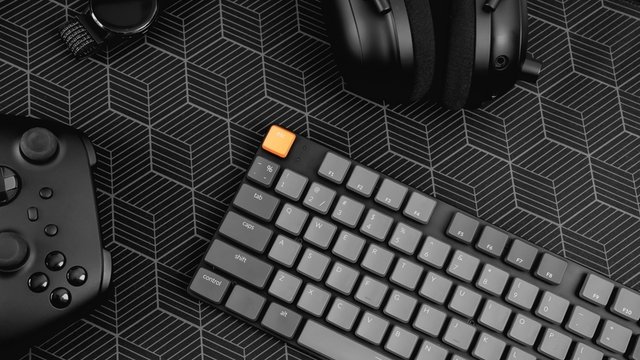 vista superior de un equipo de juego, ratón, teclado, joystick, portátil de juegos sobre fondo negro de mesa