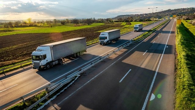 tres camiones circulando por carretera