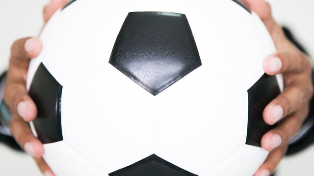 imagen de una manager de fútbol sosteniendo un balón