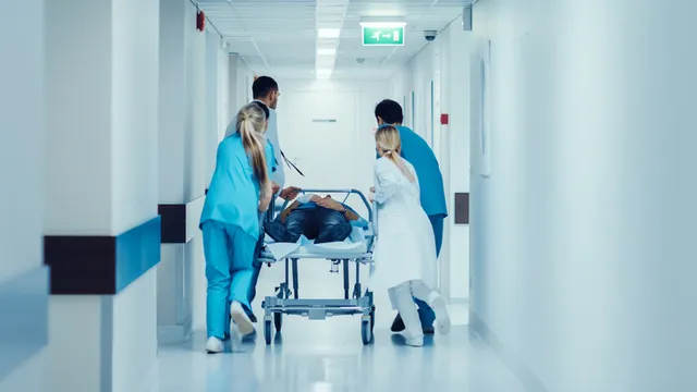 enfermeros de urgencias atendiendo a un paciente en camilla