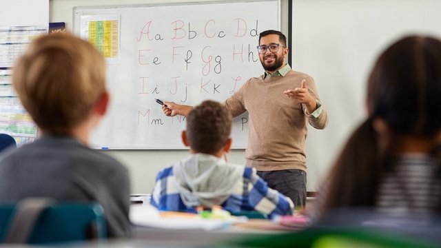 profesor sonriente enseñando el alfabeto a sus estudiantes