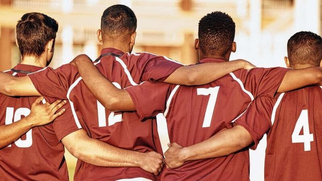 Imagen de un equipo deportivo motivado abrazándose