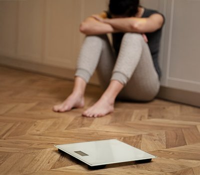 mujer-con-trastorno-alimentario-llorando-junto-una-escala.jpg