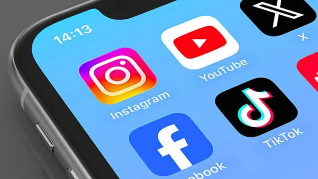 Close-up shot of a smartphone screen displaying popular social media app icons, including Instagram, YouTube, X, Facebook and TikTok.