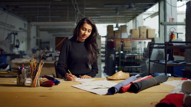 mujer creando patrones de moda en papel