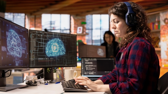 Técnico de inicio de la industria de IA que codifica y escucha música en la oficina. Empleado de la empresa de Silicon Valley con auriculares que aprovecha la tecnología de inteligencia artificial en el espacio de trabajo
