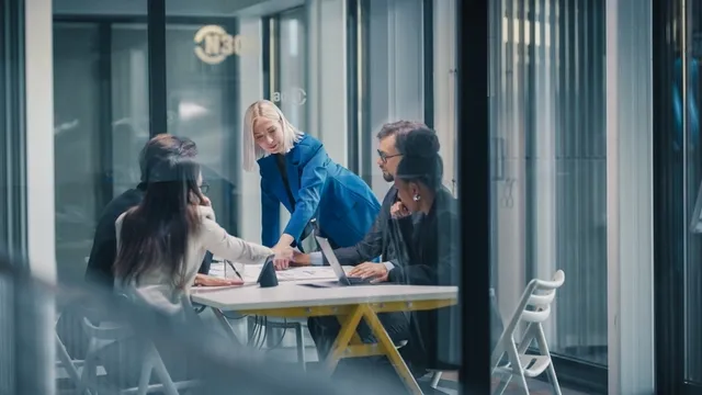 una directora dirige una reunión de negocios en una oficina de cristal
