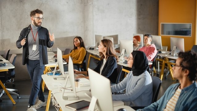 profesor impartiendo clase en un aula de informática