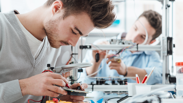 dos estudiantes en una laboratorio realizan un experimento de electrónica