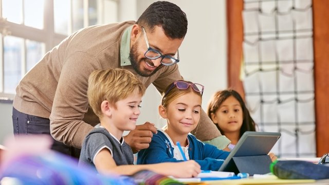 psicopedagogo ayudando a unos estudiantes a hacer sus tareas en el aula