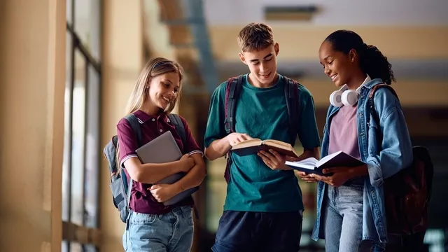 grupo de estudiantes de secundaria felices aprendiendo en un pasillo