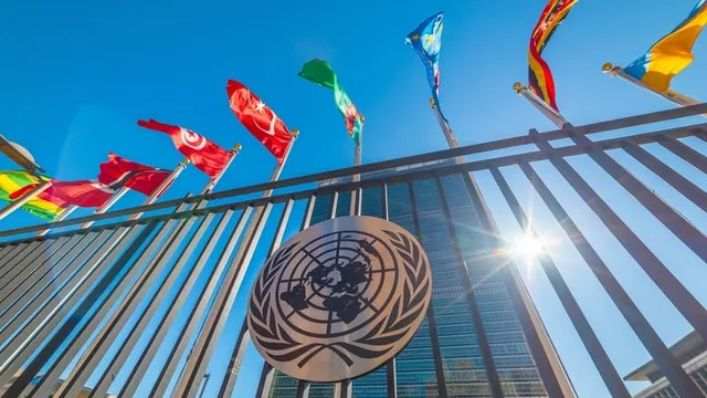 edificio de las naciones unidas con banderas bajo un cielo azul