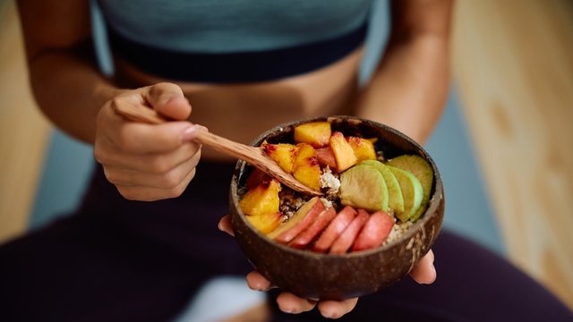 primer plano de una deportista tomando comida pre-entreno saludable