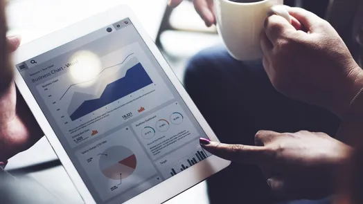 una persona señala unos gráficos que aparecen en la pantalla de una tableta