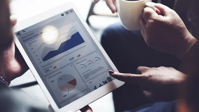una persona señala unos gráficos que aparecen en la pantalla de una tableta