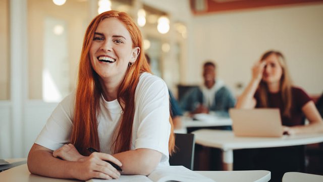 retrato de una chica sonriente sentada en un aula de Formación Profesional
