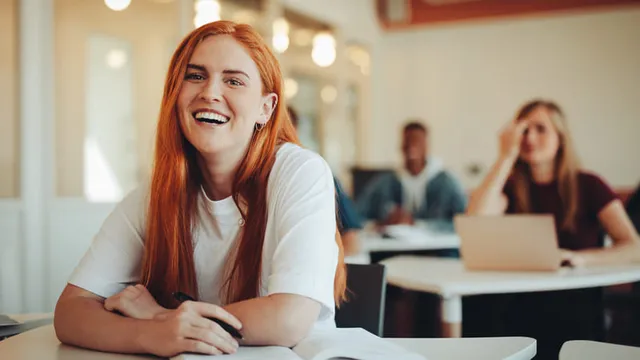 retrato de una chica sonriente sentada en un aula de Formación Profesional