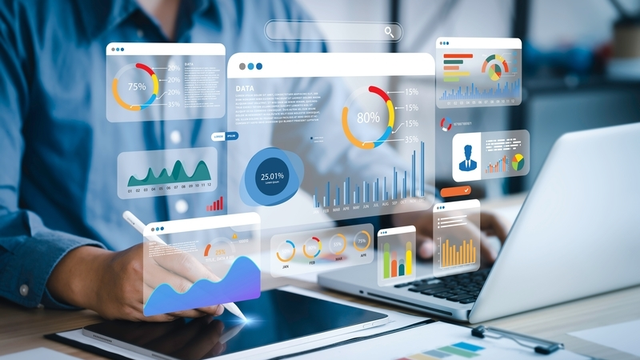 analista utiliza un ordenador y una tableta para analizar los datos de negocio de una empresa