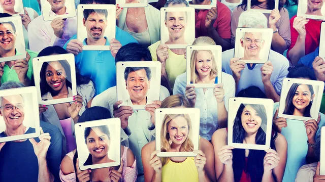 grupo de personas sosteniendo fotografías de sus caras