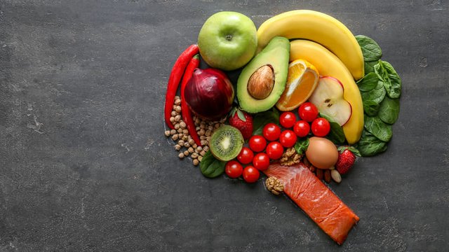 diferentes alimentos saludables forman un cerebro humano sobre un fondo gris