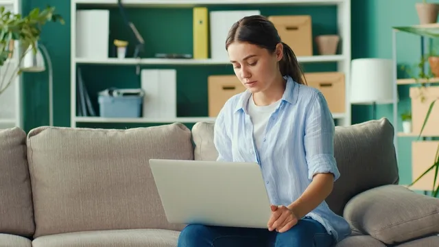 chica trabajando en remoto desde el sofá de su casa