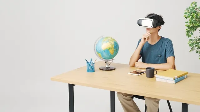 Estudiante joven sentado en su escritorio y usando gafas de RV, realidad virtual y concepto educativo