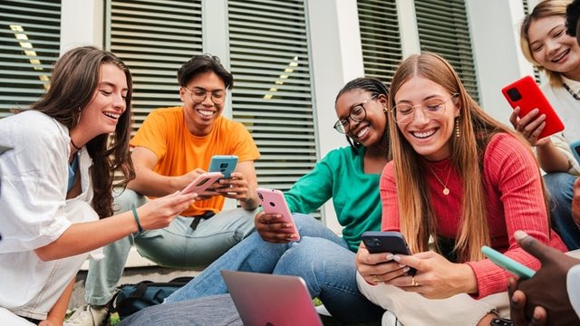 adolescentes compartiendo vídeos en las redes sociales con un smartphone