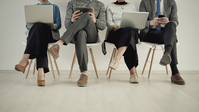 personas sentadas en una sala esperan su turno para una entrevista de trabajo