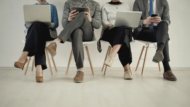 personas sentadas en una sala esperan su turno para una entrevista de trabajo