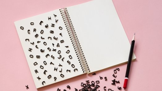 letras del alfabeto latino dispersas sobre la página de un cuaderno