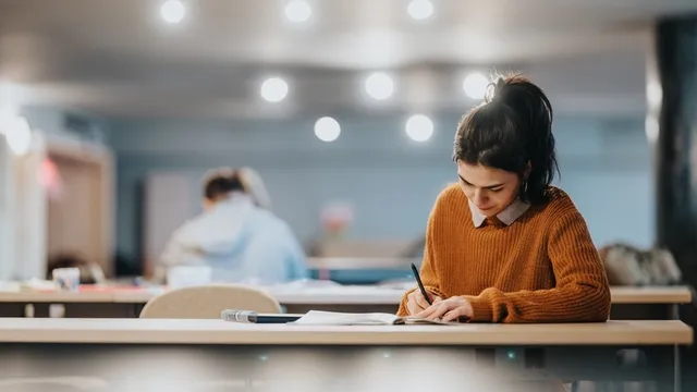 chica joven está concentrada estudiando en una biblioteca