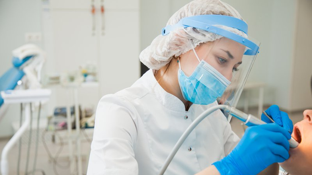 higienista bucodental haciendo una limpieza a un paciente