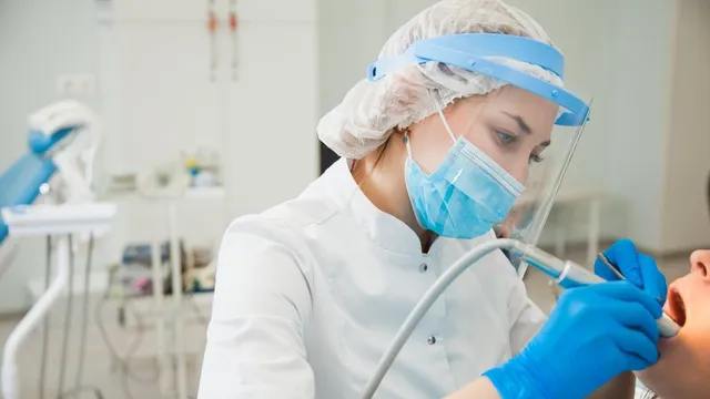 higienista bucodental haciendo una limpieza a un paciente