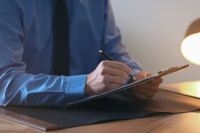 Perito judicial trabajando con documentos en su escritorio