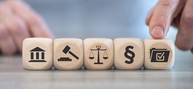 iconos en dados de madera que representan el concepto de compliance penal