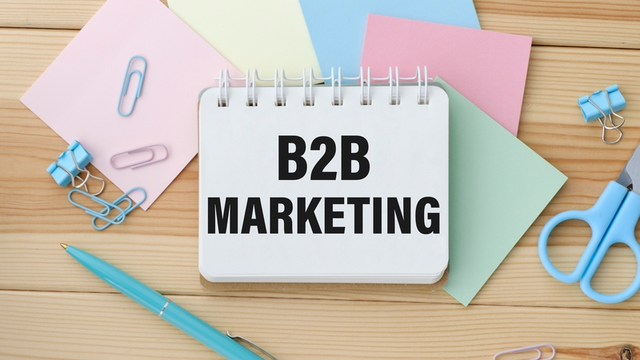 Cuaderno con notas sobre estrategias de marketing B2B junto a material de oficina