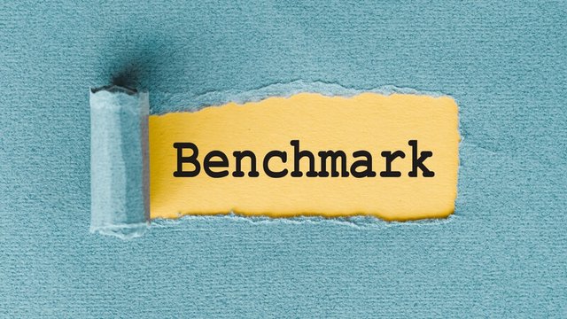 Papel rasgado mostrando la palabra "benchmark" en el interior