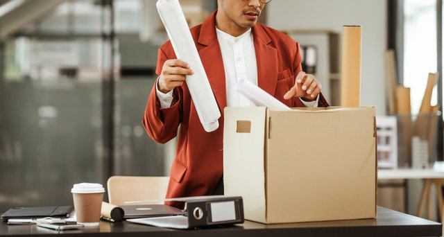 Empleado recogiendo sus pertenencias de oficina durante proceso de excedencia laboral