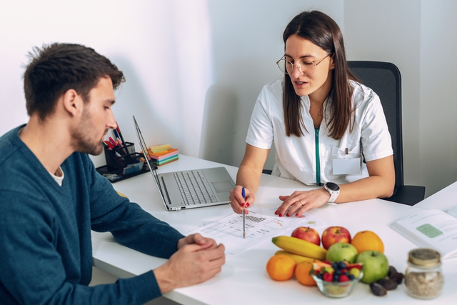 Nutrióloga creando plan de alimentación junto a un paciente