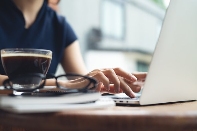 Consultora SEO trabajando en su ordenador portátil junto a una taza de café