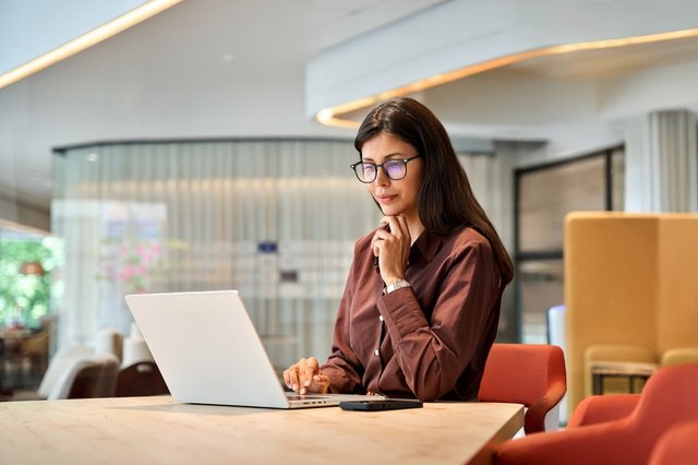 Joven mujer estudiando en su portatil