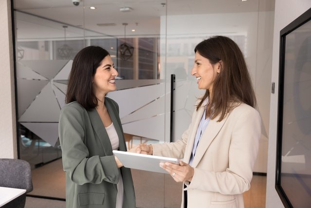 Mujer de Recursos Humanos saludando amablemente a una candidata