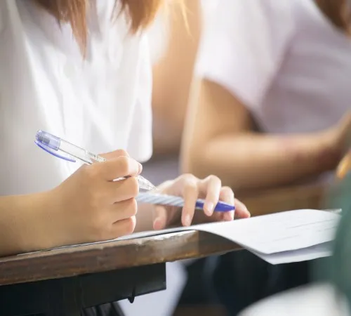 A student writing on a paper