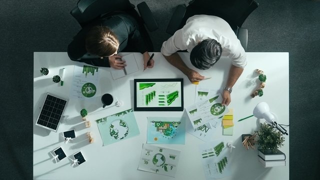 personas reunidas en una sala estudiando temas empresariales de sostenibilidad